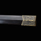 Gros plan sur l’embout du fourreau en ébène de l’épée chinoise Jian HAN YUN, avec garniture métallique dorée gravée, bois sombre poli et fond noir.