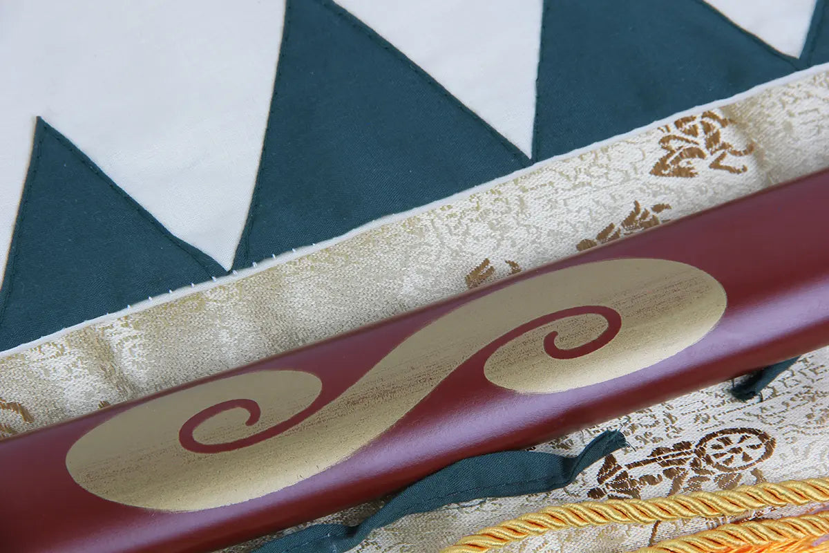 Détail du motif spirale doré peint sur le fourreau rouge du katana Mugen, élément emblématique de la série Samurai Champloo.