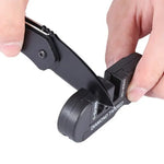 Aiguiseur de poche multifonction 3-en-1 Blade Bushido utilisé pour affûter un couteau noir sur fond blanc, montrant les zones d’affûtage en tungstène et céramique avec lame insérée, outil compact idéal pour camping, bushcraft et entretien de couteaux.