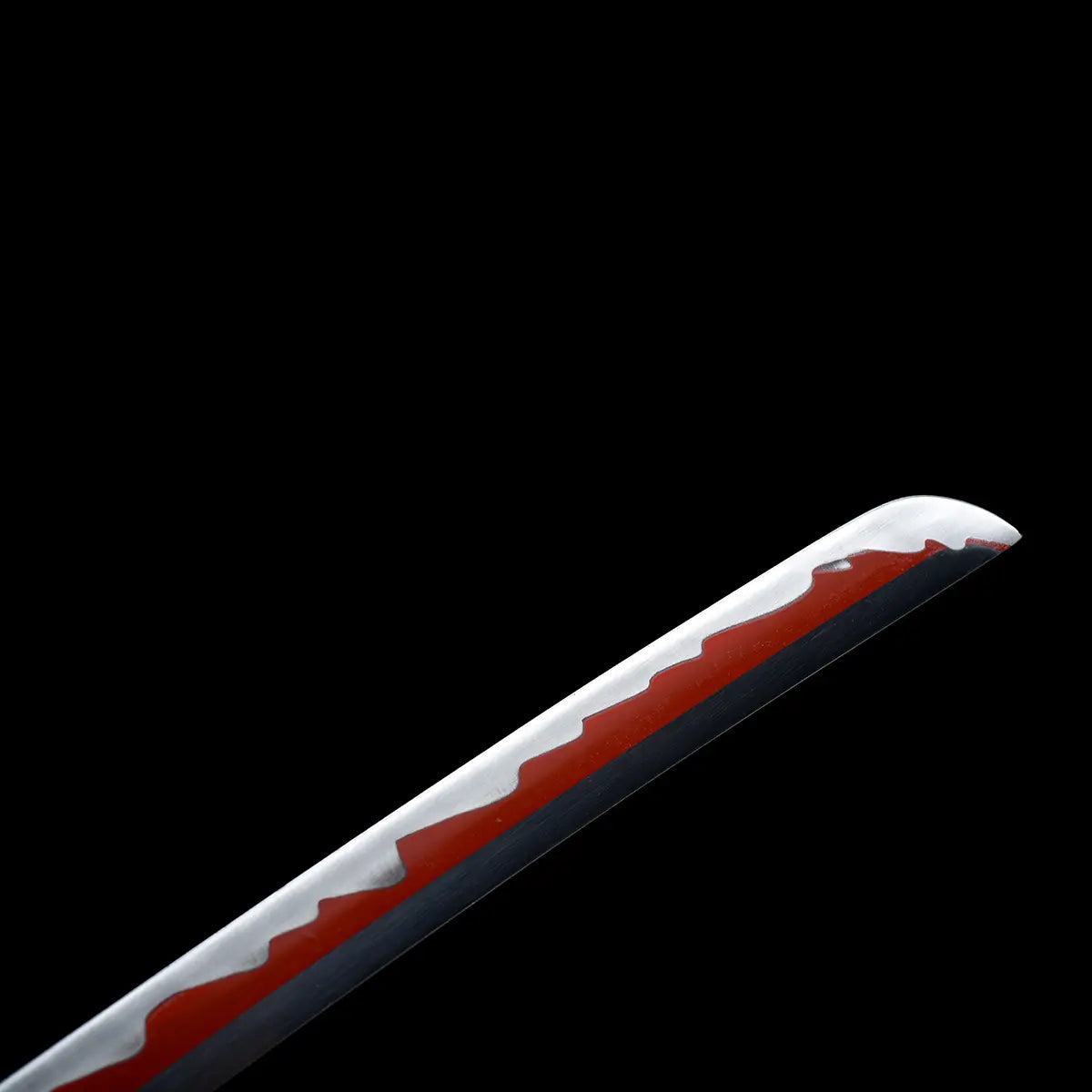 Gros plan sur la lame du katana Enma Black, hamon ondulé rouge sur acier carbone poli.