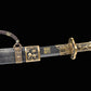 Sabre chinois Dao BAI LONG partiellement sorti de son fourreau sur fond noir, avec lame sombre gravée, inscription dorée visible, garde en laiton, poignée décorée et fourreau texturé avec garnitures dragon.