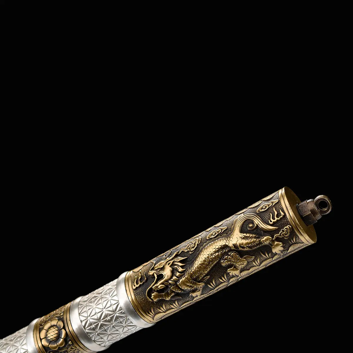 Gros plan sur le pommeau du sabre chinois Dao BAI LONG sur fond noir, avec extrémité ornée d’un dragon en relief, garnitures en laiton doré, anneau métallique et poignée blanche texturée partiellement visible.
