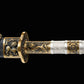 Gros plan du sabre chinois Dao BAI LONG avec poignée blanche texturée, garnitures en laiton ornées de motifs dragon, fourreau sombre partiellement visible et fond noir avec interface d’édition affichée en arrière-plan.