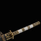 Gros plan du sabre chinois Dao BAI LONG sur fond noir, avec poignée blanche texturée, garnitures en laiton ornées de motifs dragon, garde dorée et fourreau sombre partiellement visible.