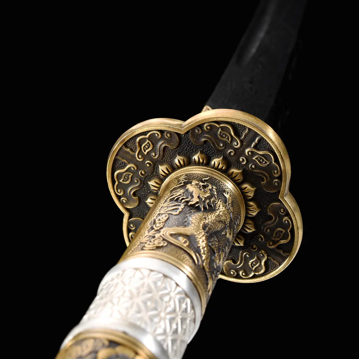 Sabre chinois Dao BAI LONG en gros plan sur fond noir, avec poignée blanche texturée, garde en laiton aux motifs décoratifs noirs et dorés, ornements dragon visibles et lame sombre en arrière-plan.