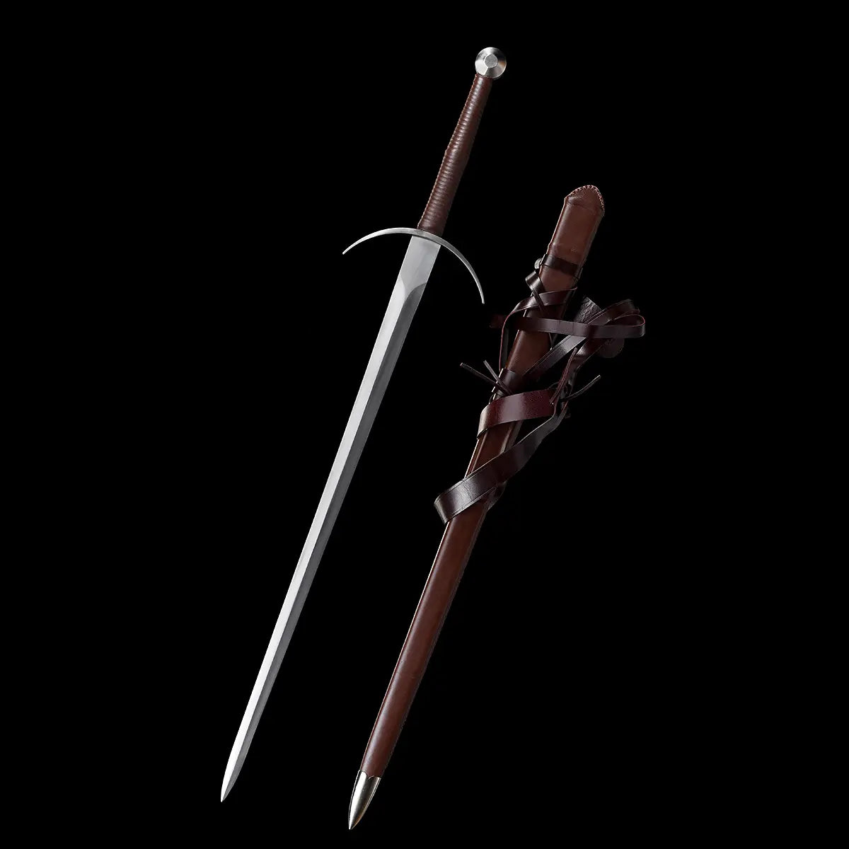 Vue d’ensemble de l’épée longue médiévale Aegis Terra, lame en acier 1060 polie, garde en croix courbée et poignée cuir brun, posée verticalement à côté de son fourreau en bois gainé de cuir brun avec longues lanières décoratives, sur fond noir minimaliste. Image mettant en valeur la silhouette complète de la longsword main-et-demi et ses finitions réalistes.