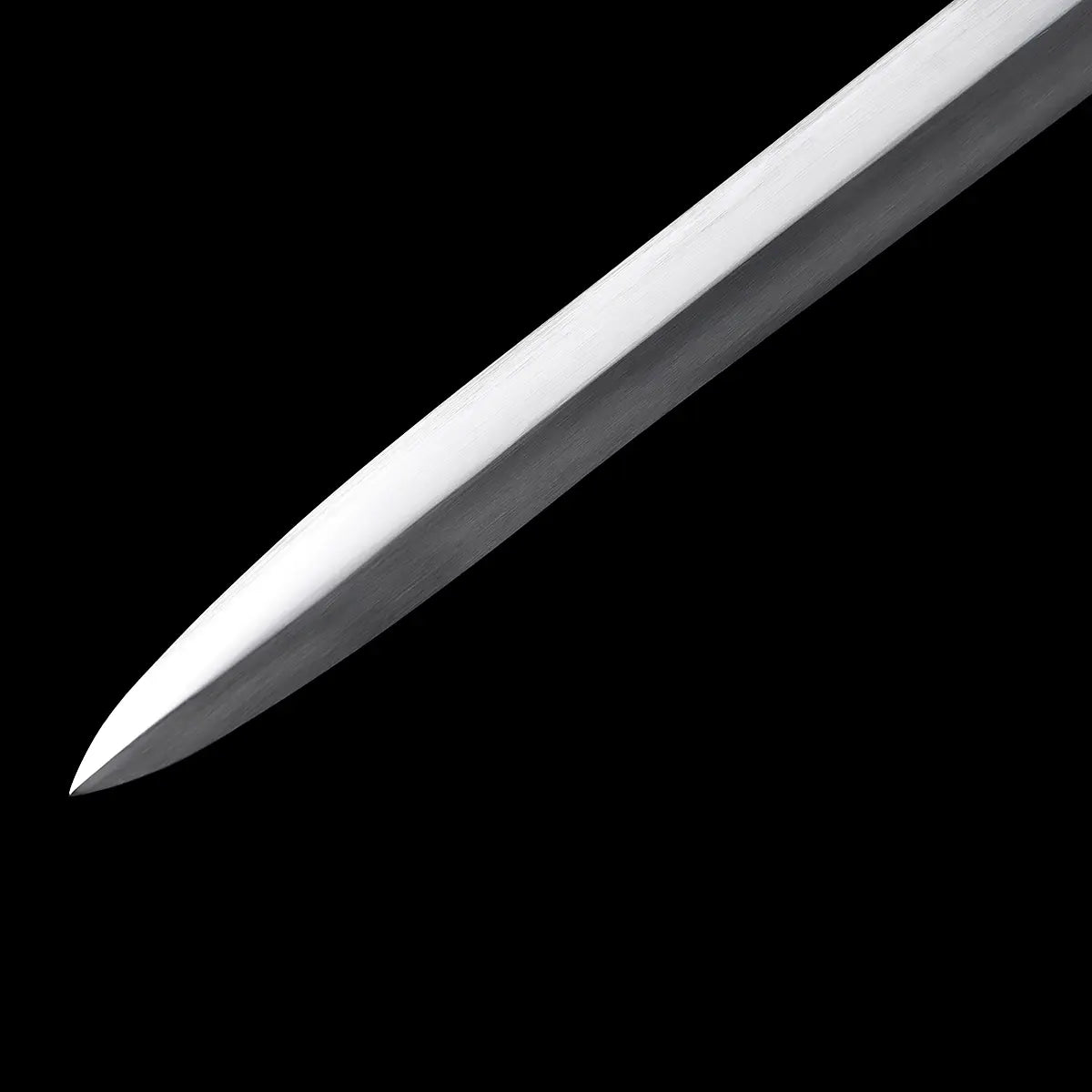 Gros plan de la pointe de l’épée longue médiévale Aegis Terra, lame en acier 1060 polie avec arête centrale visible, sur fond noir uniforme. Image détaillée montrant le tranchant, la finition satinée et la géométrie de la lame, idéale pour illustrer une longsword main-et-demi de type médiéval.