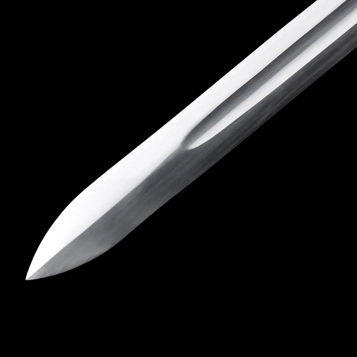 Gros plan sur la pointe de l’épée longue “Brune-Lame”, lame en acier 1060 polie avec gouttière centrale, finition satinée sur fond noir ; mise en valeur du tranchant et du travail du métal pour présentation produit Blade Bushido.