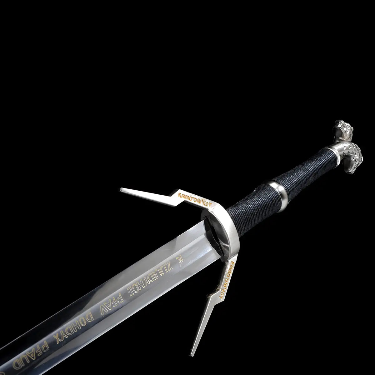 Vue rapprochée de la garde et du départ de la lame de l’épée longue Geralt de Riv The Witcher 3 sur fond noir uniforme, lame droite en acier poli avec inscriptions décoratives dorées visibles sur le plat, garde en croix anguleuse en métal argenté avec quillons asymétriques gravés, poignée longue gainée de cuir noir en enroulement serré, pommeau métallique partiellement visible, rendu fidèle à l’esthétique fantasy médiévale pour cosplay, collection et observation AMHE ou HEMA décorative
