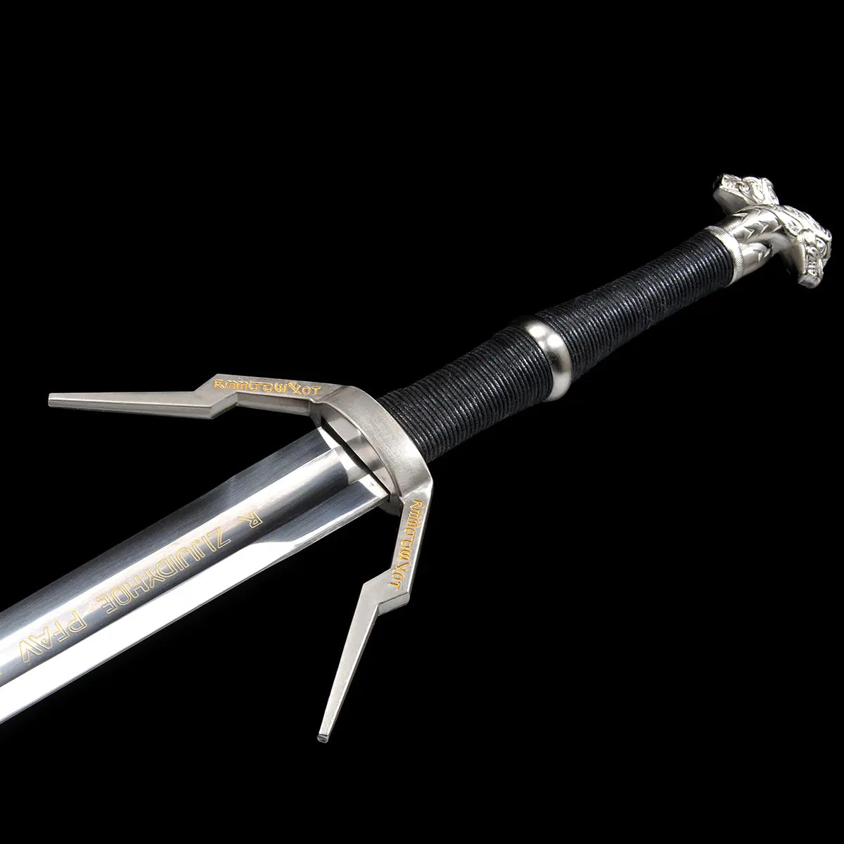 Vue détaillée de la garde et de la poignée de l’épée longue Geralt de Riv The Witcher 3 sur fond noir uniforme, lame droite en acier poli avec inscriptions décoratives visibles près du ricasso, garde en croix anguleuse en métal argenté avec quillons droits gravés dorés, poignée longue gainée de cuir noir en enroulement serré, pommeau métallique sculpté à finition argentée, présentation fidèle à l’esthétique fantasy médiévale pour cosplay, collection et observation AMHE ou HEMA décorative
