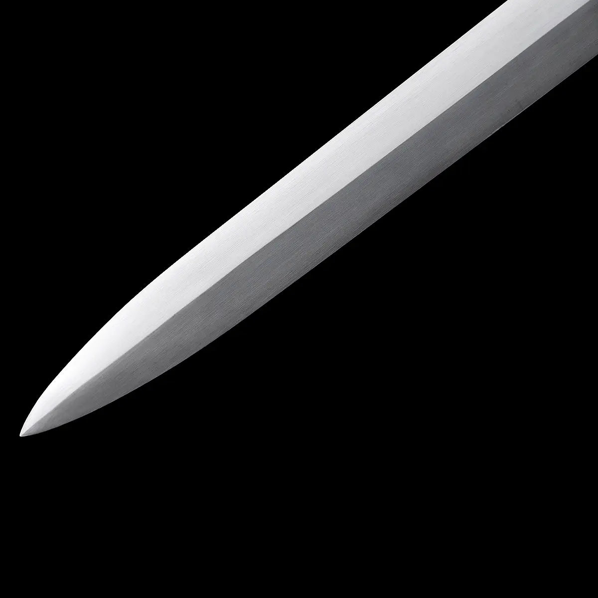 Gros plan sur la pointe de l’épée longue médiévale Corvus, lame droite en acier carbone 1060 finition satinée, tranchant net et géométrie rigide, photographiée sur fond noir profond, ambiance sombre et martiale mettant en valeur la précision de la forge et le potentiel de coupe.