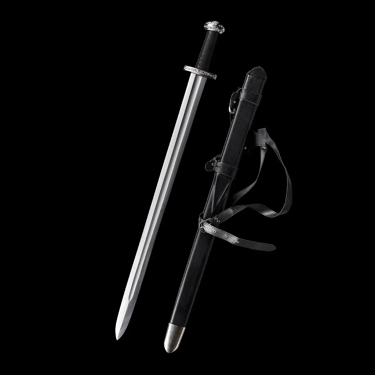 Épée longue médiévale Ravenna dégainée, présentée aux côtés de son fourreau en cuir noir, sur fond noir profond. Lame droite en acier 1060 polie, avec gouttière centrale, garde en croix métallique et pommeau évasé. Poignée gainée cuir noir offrant une prise ferme, idéale pour la pratique AMHE / HEMA, la coupe légère ou la collection médiévale.