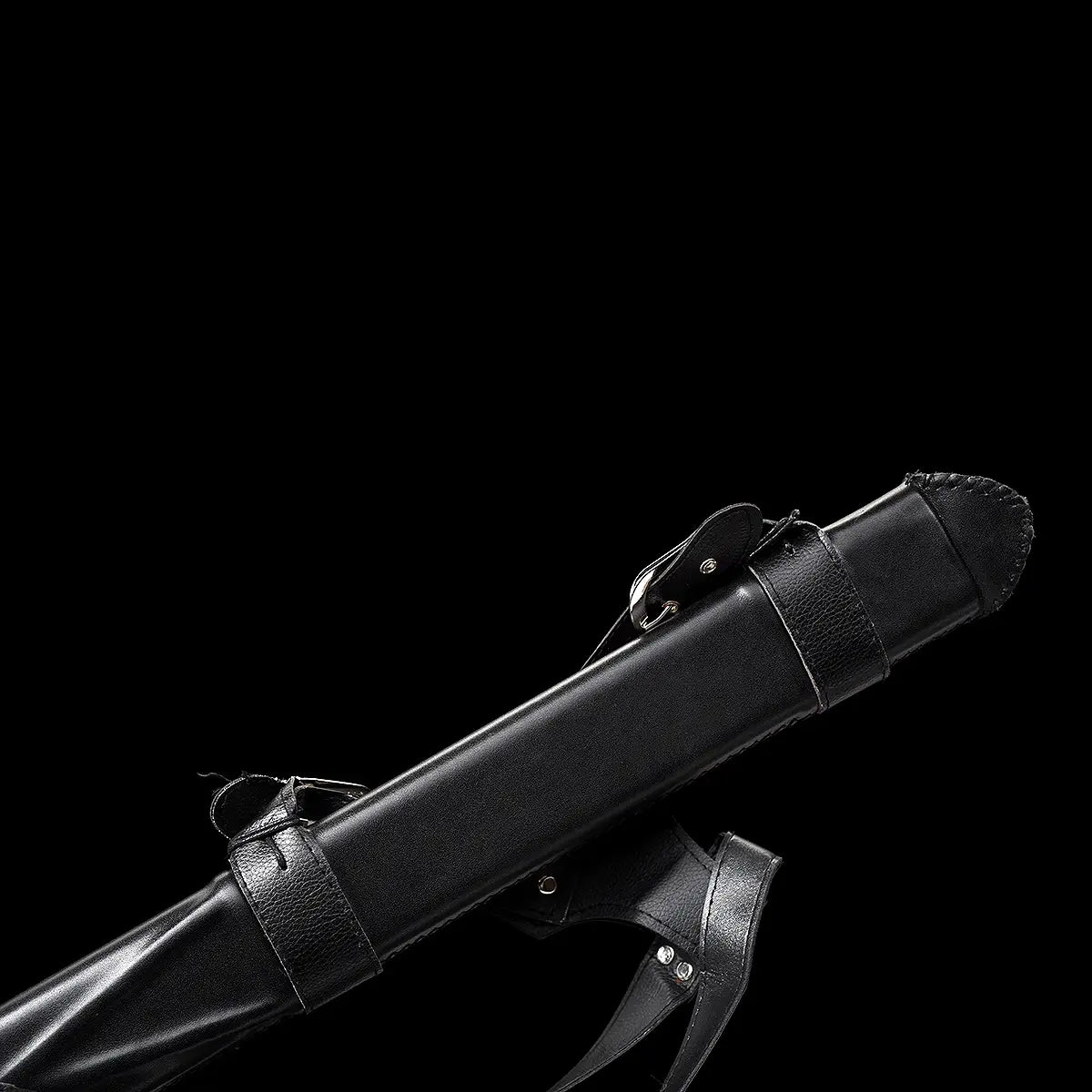 Détail du fourreau de l’épée longue médiévale Ravenna sur fond noir uniforme. Fourreau en bois gainé de cuir noir, équipé de lanières de port réglables et de passants rivetés, offrant une tenue stable à la ceinture. Finition sobre et robuste, pensée pour le transport, la pratique AMHE / HEMA ou la présentation en collection médiévale.