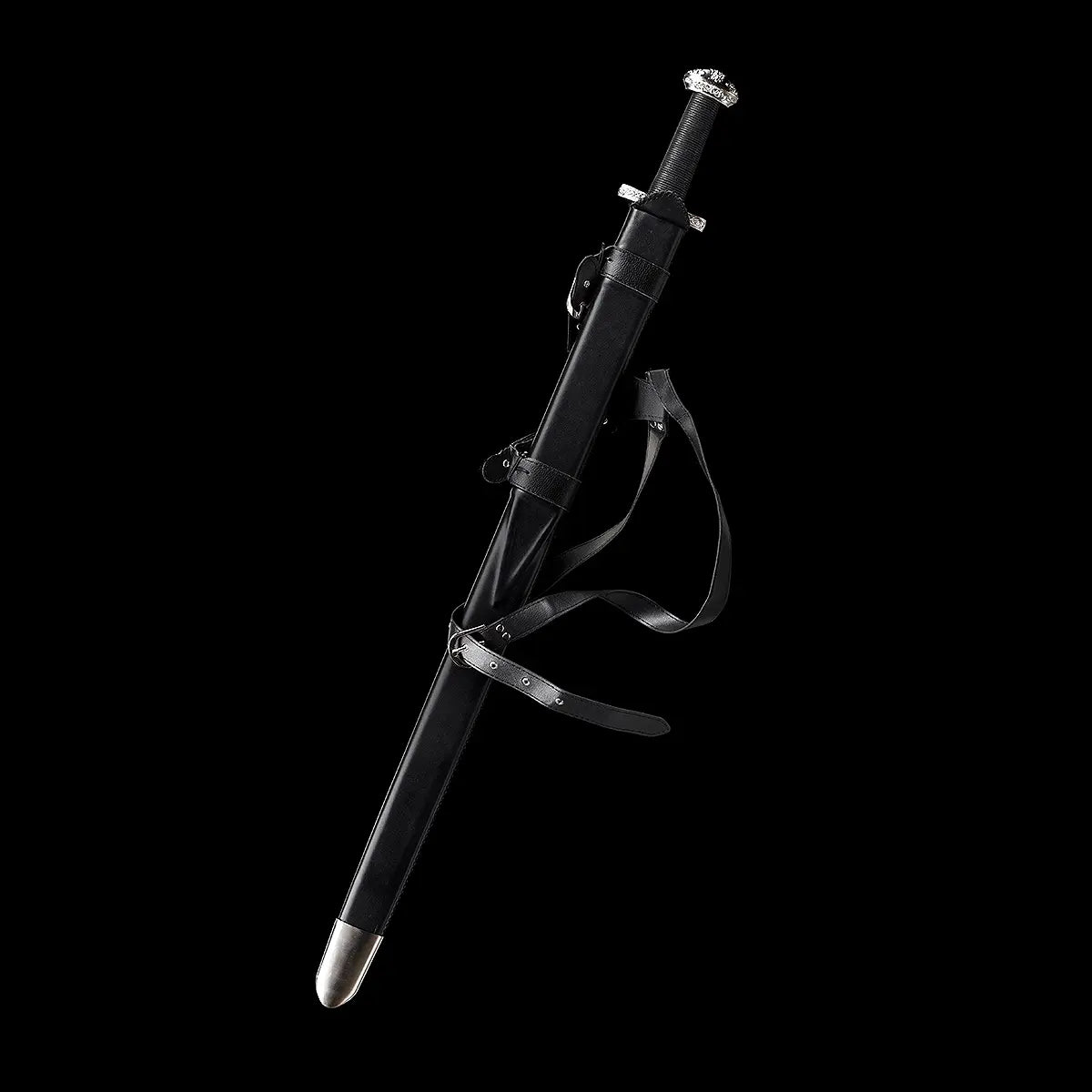 Épée longue médiévale Ravenna présentée dans son fourreau en cuir noir, posée en suspension sur fond noir uniforme. Fourreau bois gainé cuir avec lanières de port, poignée gainée cuir noir et garde en croix en métal argenté. Ambiance sombre et minimaliste, idéale pour collection, décoration, pratique AMHE ou HEMA.