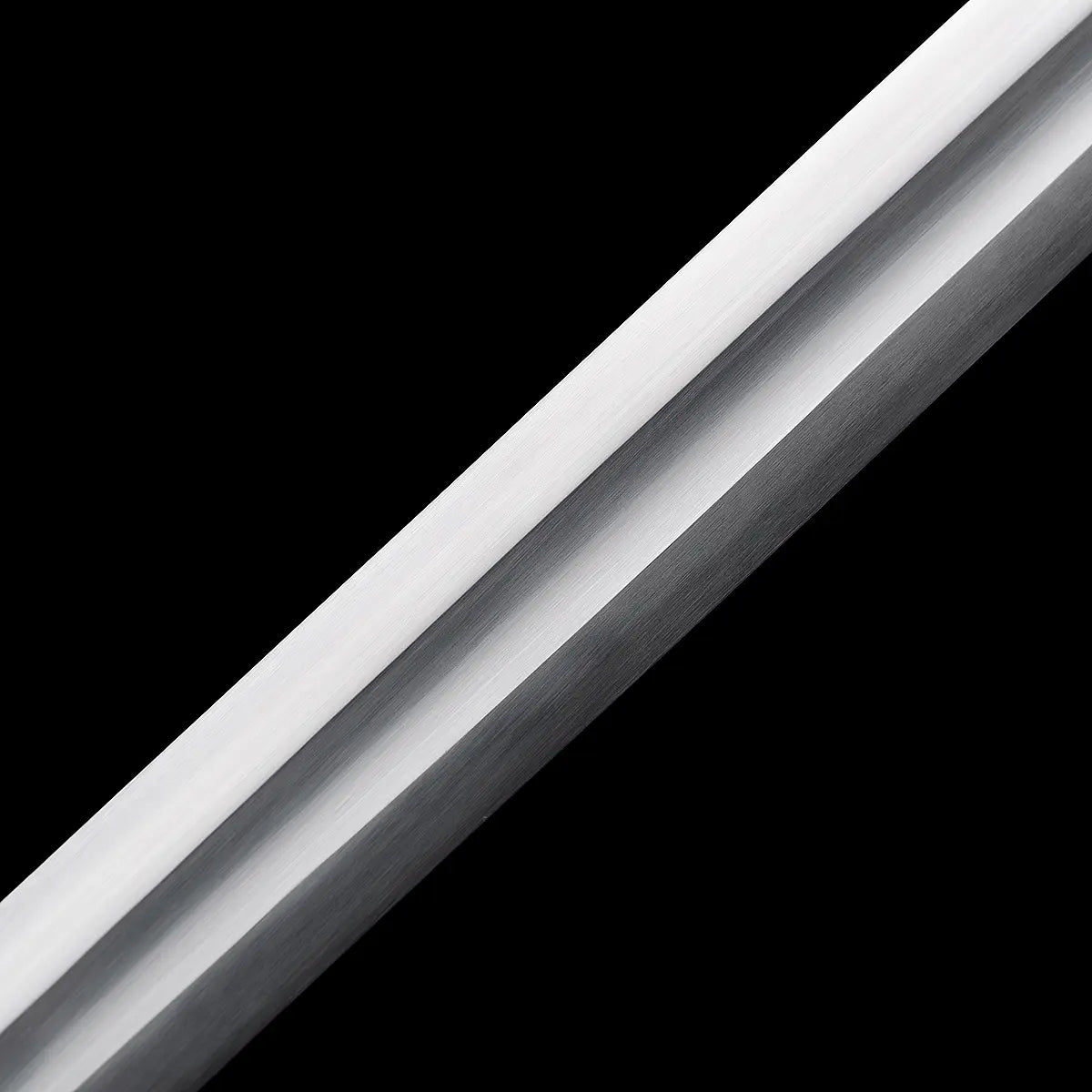 Gros plan sur la lame de l’épée longue médiévale Ravenna, photographiée en diagonale sur fond noir profond. Lame droite en acier 1060 avec gouttière centrale bien marquée, polissage satiné uniforme et arêtes nettes. Finition sobre et fonctionnelle, adaptée à la pratique AMHE / HEMA, à la coupe légère et à la collection médiévale.