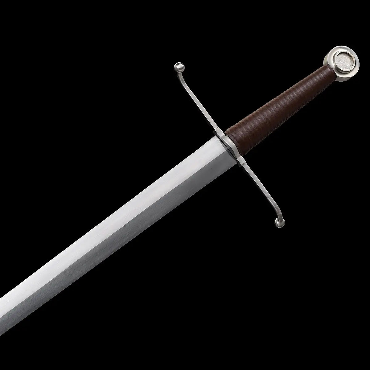 Détail de l’épée longue médiévale Valmont sur fond noir, garde en croix en acier poli avec quillons courbés, poignée main-et-demi gainée de cuir brun foncé, lame droite en acier 1060 à finition satinée, style sobre et authentique pour pratique HEMA ou collection.
