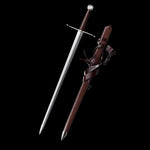 Épée longue médiévale Valmont en acier 1060 affûtée, lame droite polie finition satinée, garde en croix acier inox, poignée main-et-demi gainée de cuir brun foncé, pommeau évasé, fourreau en bois gainé cuir brun avec lanières, présentation sur fond noir studio, ambiance sombre et minimaliste, style HEMA, collection et décoration