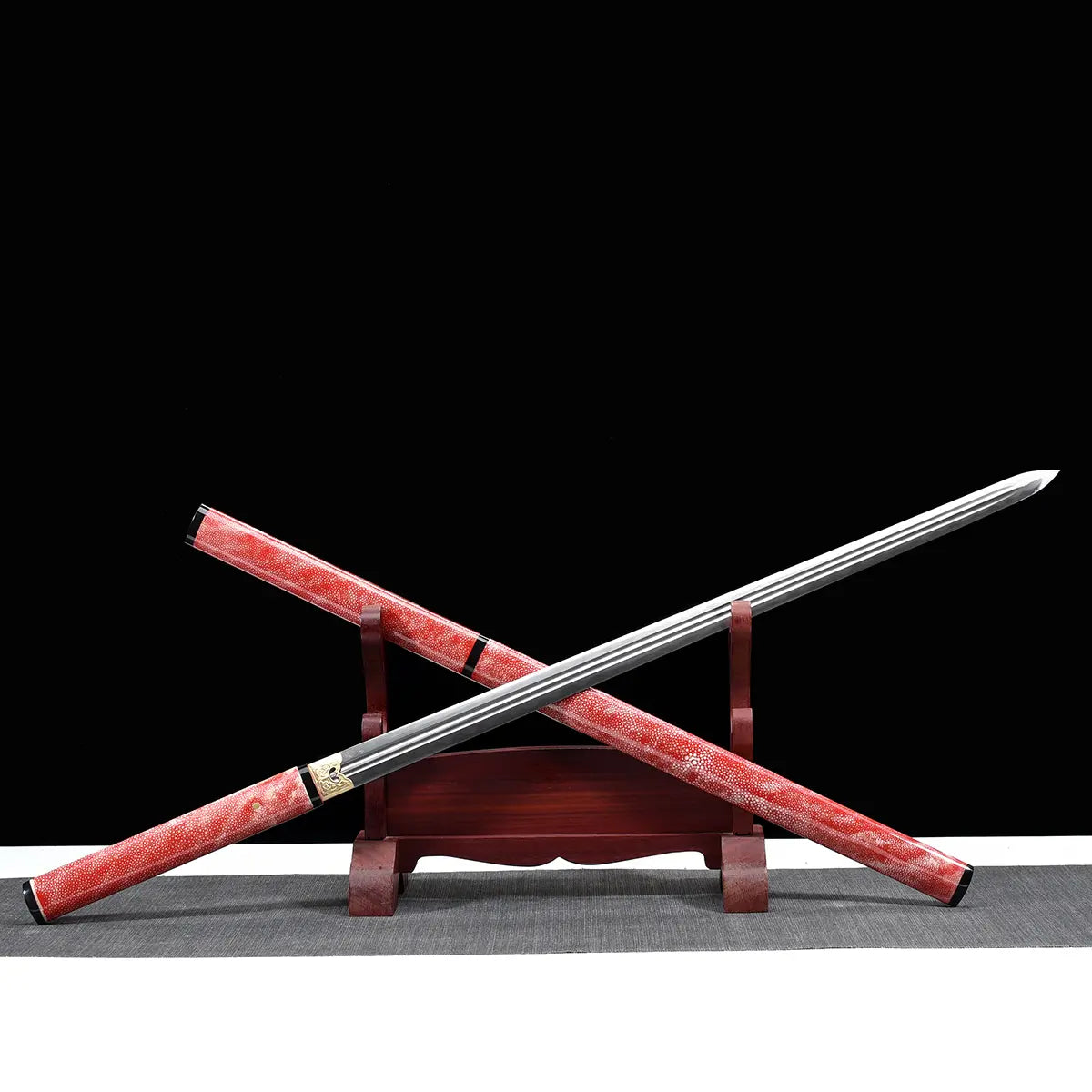 Épée chinoise Jian FEN LIN présentée en position croisée sur un support en bois, avec lame droite double tranchant en acier, fourreau rose en peau de raie, poignée assortie, finitions noires brillantes, fond noir et tapis gris.