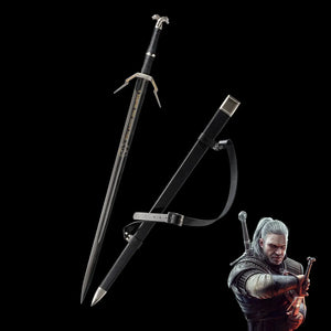 Geralt long sword replica displayed on a deep black background, blade unsheathed next to its black scabbard with leather belt strap attached. The sword features a straight double-edged steel blade with a central fuller and gold engraved inscription near the spine. The crossguard is angular and silver with extended quillons, the grip is wrapped in black textured leather, and the pommel is silver with a wolf head detail. The scabbard is matte black with a metal chape and locket in silver tone.  
