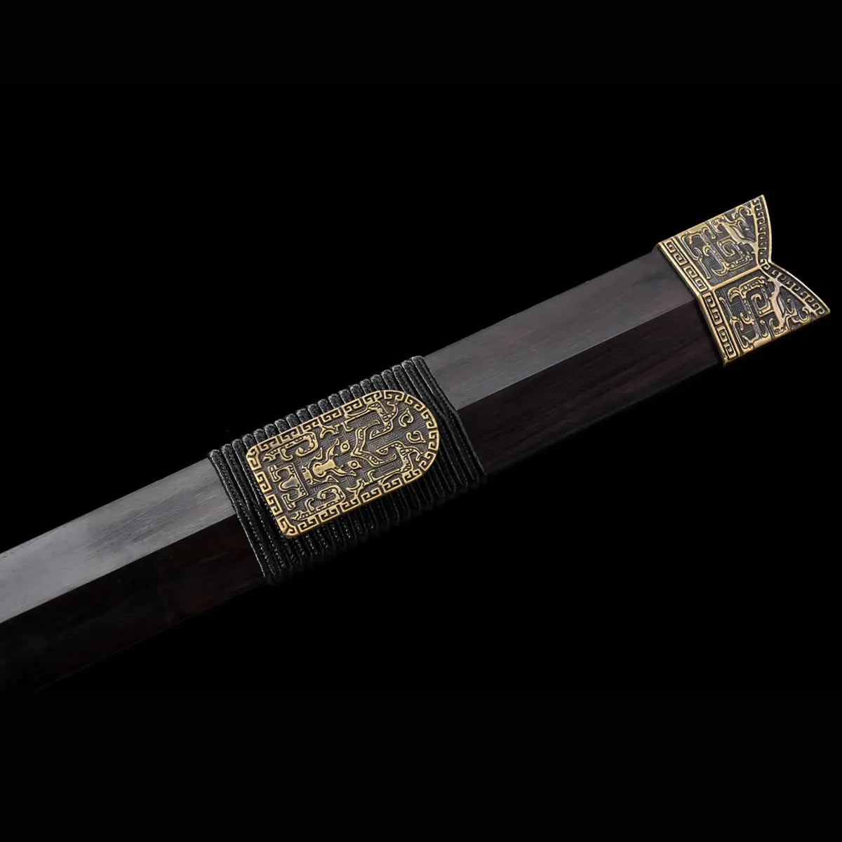 Gros plan sur le fourreau en ébène de l’épée chinoise Jian HAN YUN, avec garnitures métalliques dorées gravées, texture sombre du bois et détails décoratifs sur fond noir.