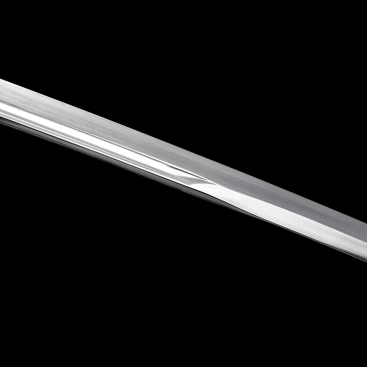 Détail rapproché de la lame du katana japonais artisanal Kazekiri mettant en évidence la gorge bo-hi et la finition de polissage, acier carbone 1060 avec surface satinée régulière et tranchant poli miroir, ligne de lame fluide et continue, fond noir uniforme soulignant la géométrie unokubi-zukuri et la qualité de la finition
