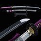 Katana japonais artisanal Murasaki no Kage présenté sur fond noir en studio, lame courbe polie posée sur un support en bois avec son fourre
