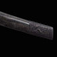 Gros plan du fourreau noir moucheté du sabre chinois Dao KANGXI LONG, avec extrémité métallique sombre gravée, motif de dragon visible, texture brillante et finition décorative sur fond noir.