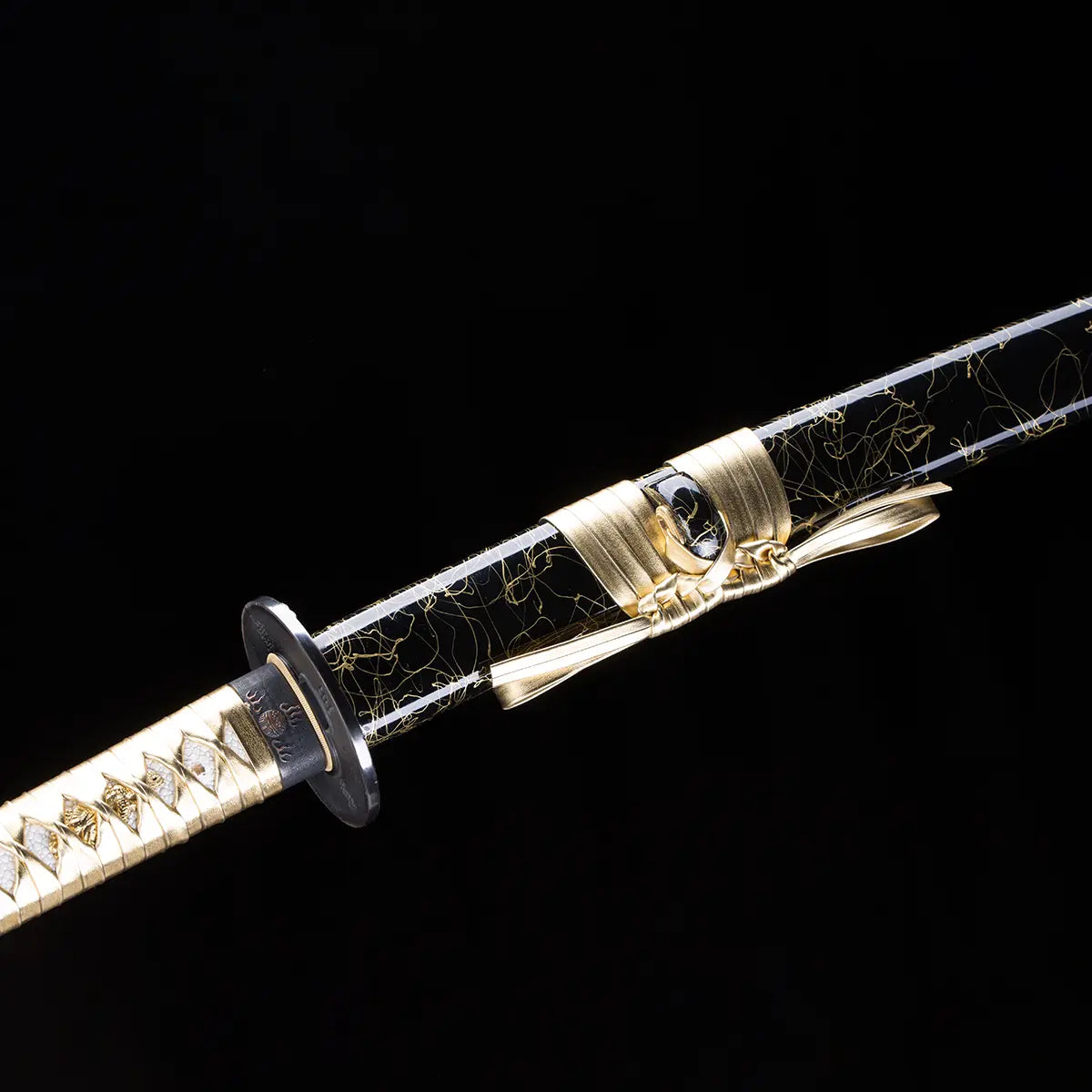 Gros plan sur le katana japonais Toyotomi Hideyoshi montrant le fourreau noir laqué or décoré de fils dorés et noué d’un sageo doré, avec garde noire et tsuka doré, sur fond noir studio Blade Bushido.