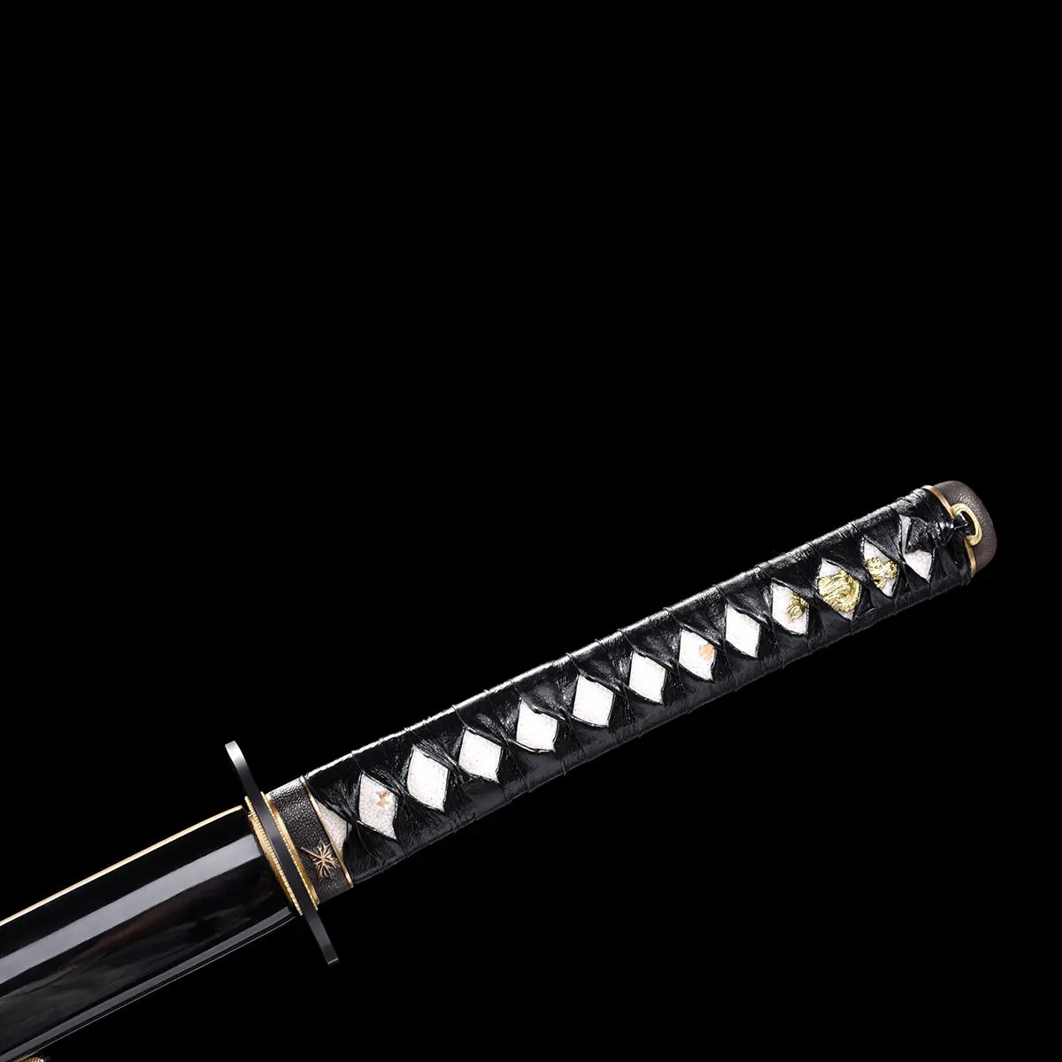 Détail du Katana de la Mariée de Beatrix Kiddo dans Kill Bill, tsuka en cuir noir tressé avec incrustations samegawa blanches et ornements dorés, garde noire sobre, fourreau laqué partiellement visible, sur fond noir.