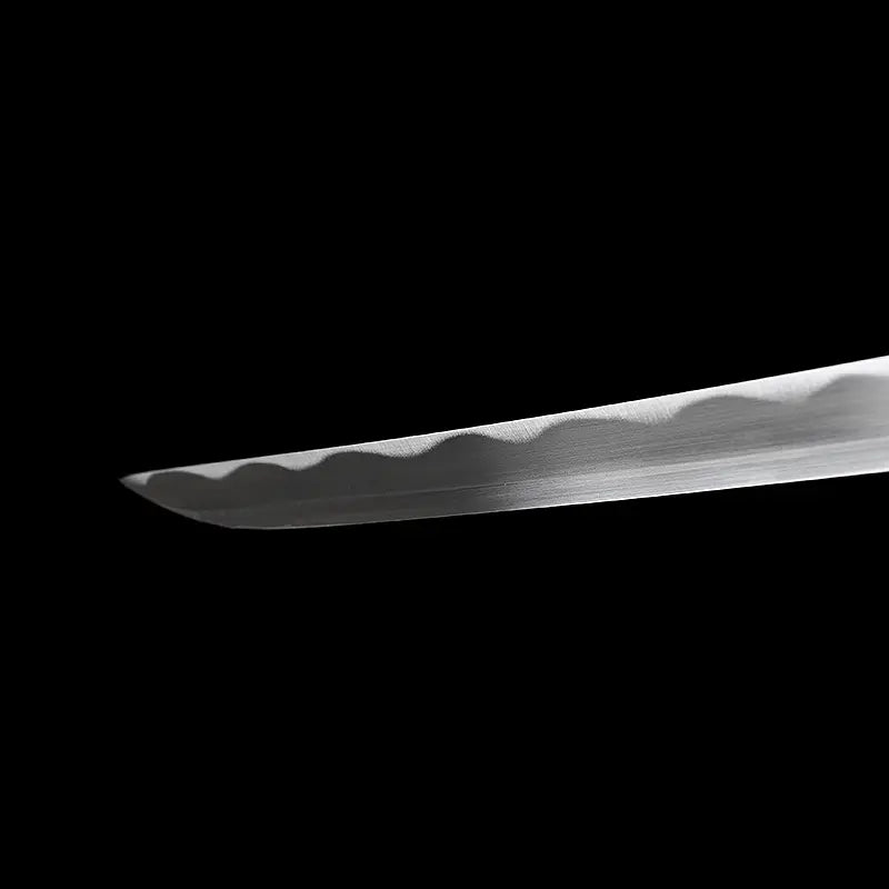 Gros plan de la pointe du katana Himura Kenshin Sakabato sur fond noir, lame inversee en acier avec ligne de trempe visible et courbure elegante, finition metallique satinée
