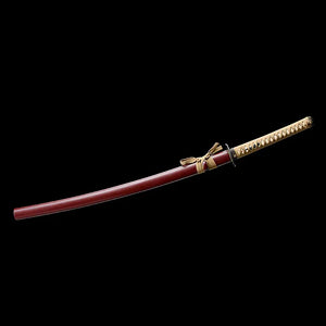 Katana Himura Kenshin Sakabato a lame inversee presente sur un fond noir uni, sabre rengaine dans un fourreau rouge laque avec cordon beige, manche tsuka beige enroule de tresse avec peau de raie apparente et garde noire ronde.
