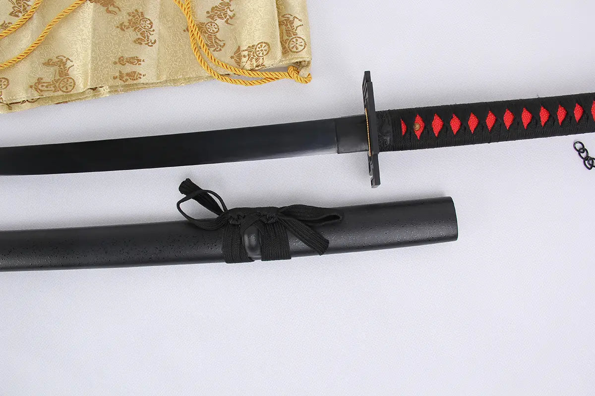 Vue rapprochée du katana Ichigo Kurosaki Tensa Zangetsu version classique, réplique Bankai de Bleach en acier carbone 1045, montrant la lame noire partiellement dégainée, le fourreau noir mat avec sageo noué, la poignée noire tressée à losanges rouges et une housse dorée en arrière-plan, sur fond blanc.