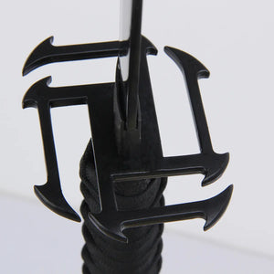 Gros plan sur la garde carrée noire du katana Ichigo Kurosaki Tensa Zangetsu version stylisée, réplique collector Bleach, avec lame acier carbone et poignée tressée noire, capturée en détail sur fond clair.