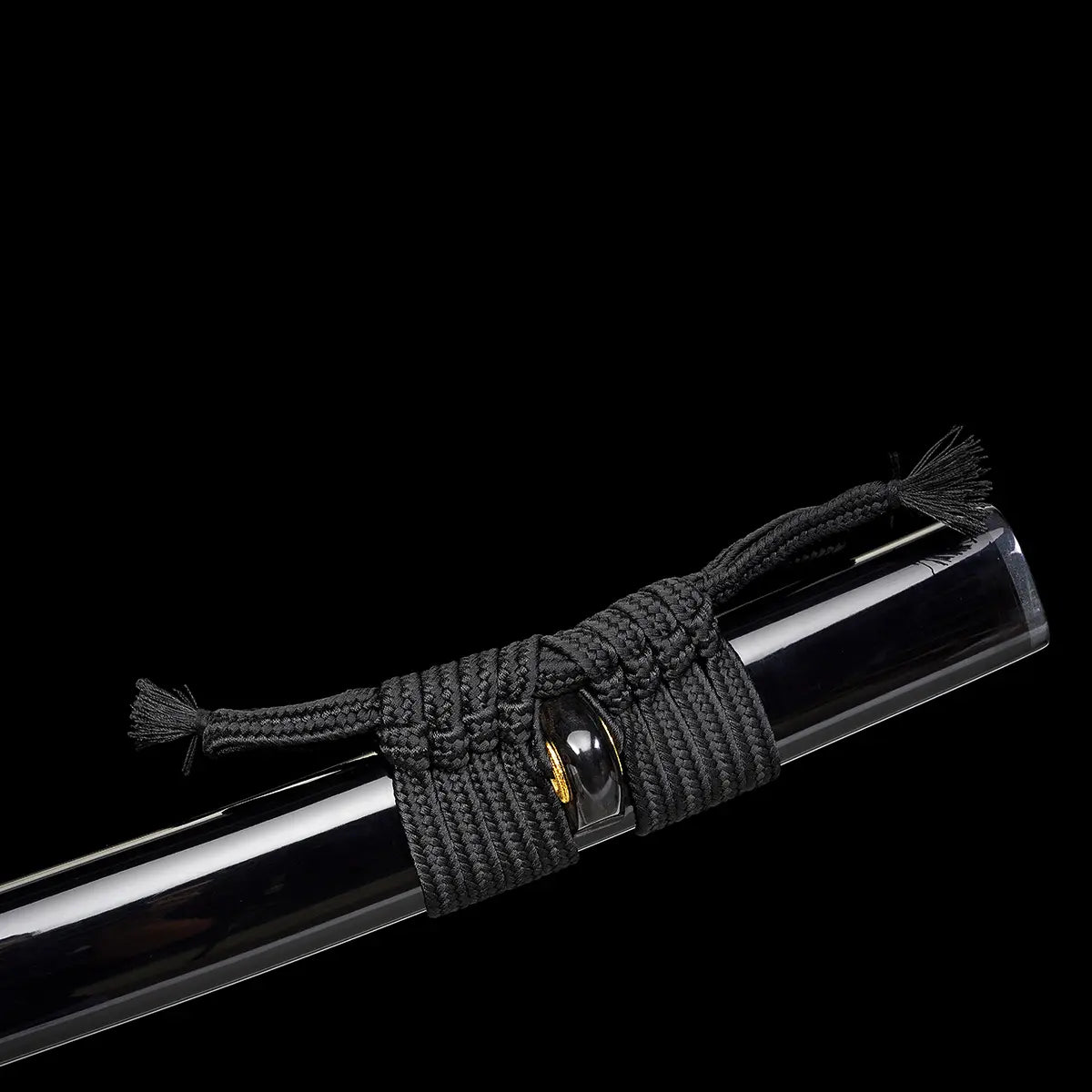 Gros plan sur le fourreau du katana japonais artisanal Ryū no Kiba sur fond noir uni, saya noir laqué avec cordage sageo noir solidement noué autour du kurigata, finition lisse et brillante du fourreau, absence de lame visible et aucun support apparent.

