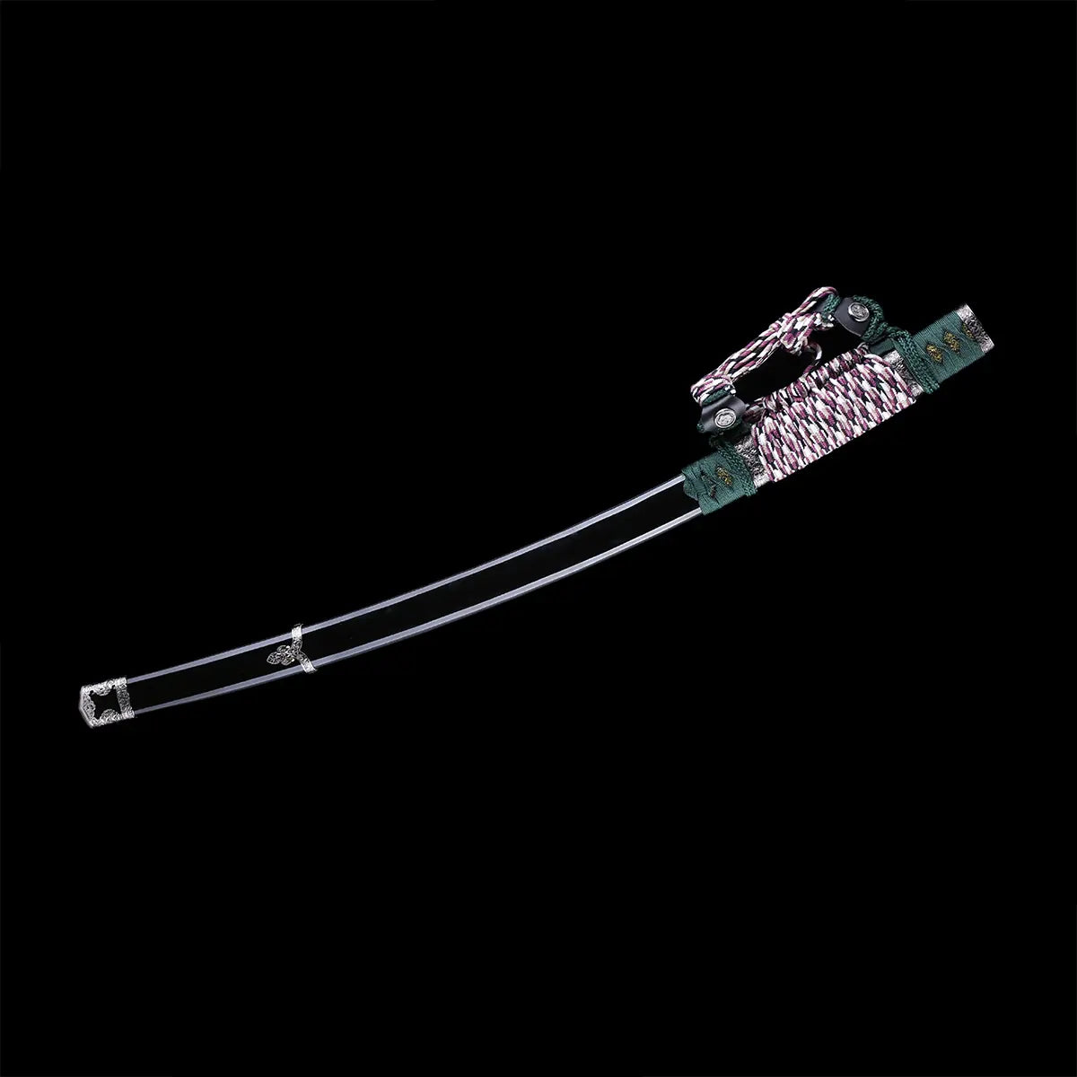 Katana japonais artisanal Seiryū no Tachi photographié sur fond noir uni, présenté avec son fourreau noir laqué. La lame courbe en acier carbone est visible partiellement, avec bohi bien marqué sur la longueur. Le manche est enveloppé d’un tsuka-ito vert foncé tressé, avec same blanche apparente en losanges. Le sageo tressé vert, blanc et pourpre est attaché au fourreau, et les montures métalliques traditionnelles sont visibles à la jonction de la lame et du manche.
