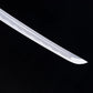 Gros plan sur la pointe (kissaki) du katana japonais Date Masamune, lame en acier plié avec hamon ondulé bien visible, finition polie brillante, photographié sur fond noir – katana de collection artisanal Blade Bushido.