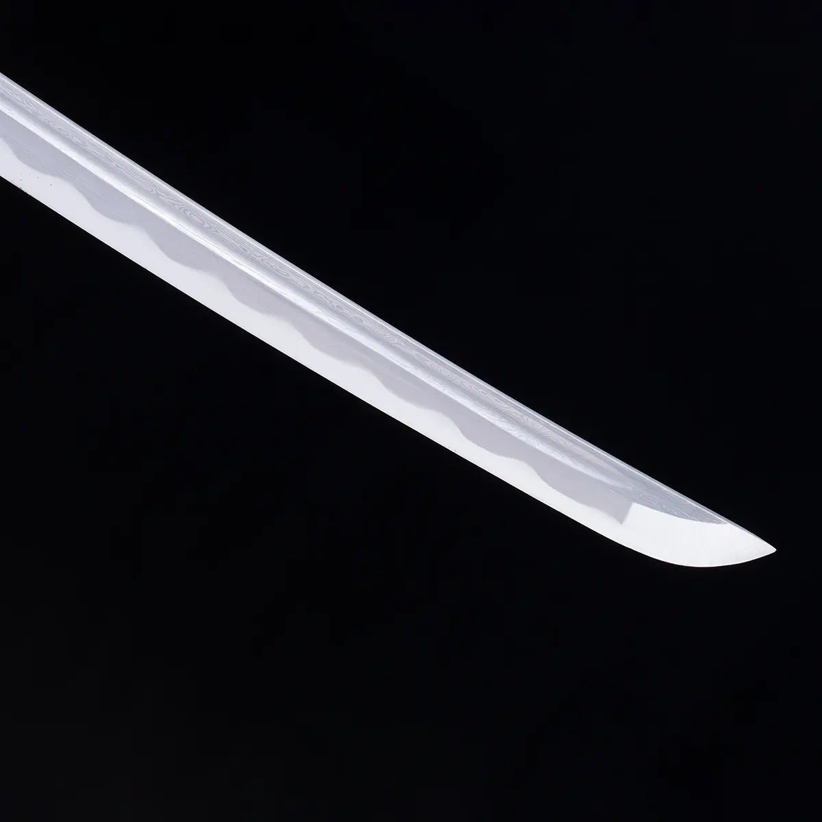 Gros plan sur la pointe (kissaki) du katana japonais Date Masamune, lame en acier plié avec hamon ondulé bien visible, finition polie brillante, photographié sur fond noir – katana de collection artisanal Blade Bushido.