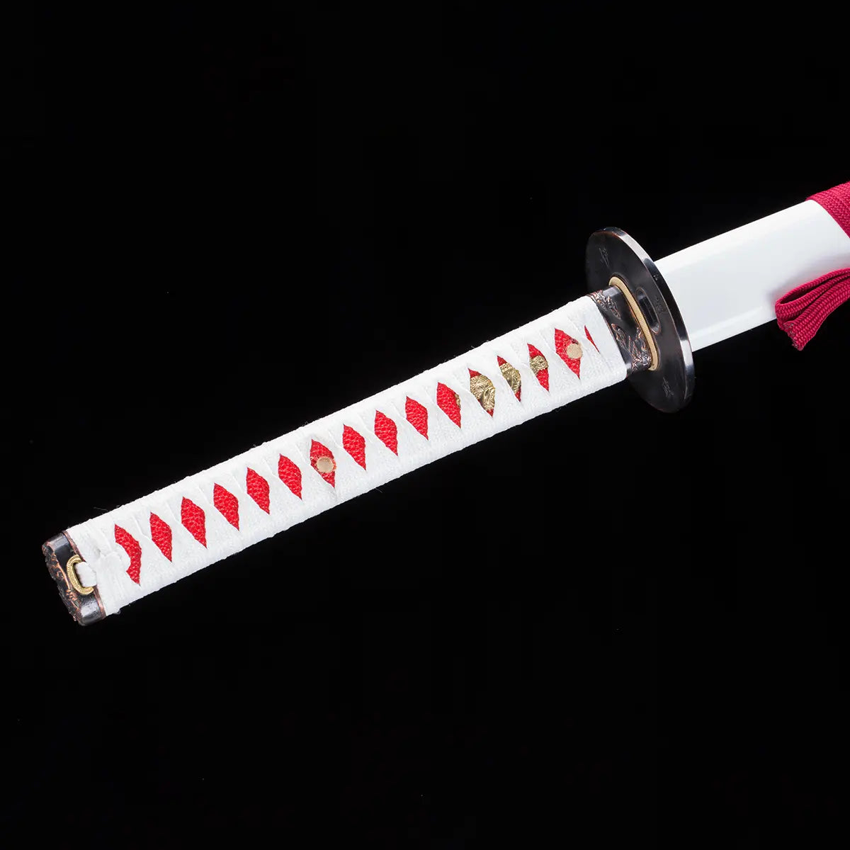 Détail du katana japonais Date Masamune, poignée (tsuka) en bois recouverte de tressage blanc avec motifs rouges et ornements dorés, garde en métal sombre, posé sur fond noir élégant – katana de collection Blade Bushido.