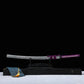 Katana japonais Murasaki no Kage dans son fourreau noir laqué à éclaboussures blanches posé sur un support en bois noir, photographié sur fond noir avec surface blanche, poignée violette tressée avec peau de raie blanche et cordon sageo violet, accompagné d’une boîte de présentation noire et d’une ho

