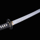 Détail de la lame gravée du katana japonais artisanal Shinshi no Ken sur fond noir, acier poli avec hamon ondulé visible, inscription japonaise le long de la lame, habaki doré, tsuba noire nervurée et manche noir avec tressage traditionnel laissant apparaître un samegawa blanc.
