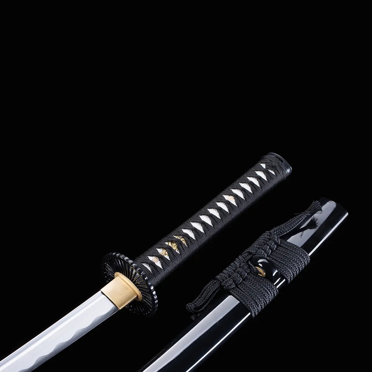 Détail du manche et du fourreau du katana japonais artisanal Shinshi no Ken sur fond noir profond, poignée noire avec tressage en losanges laissant apparaître un samegawa blanc et des menuki dorés, tsuba noire nervurée, habaki doré, saya noir laqué brillant avec sageo gris foncé noué.

