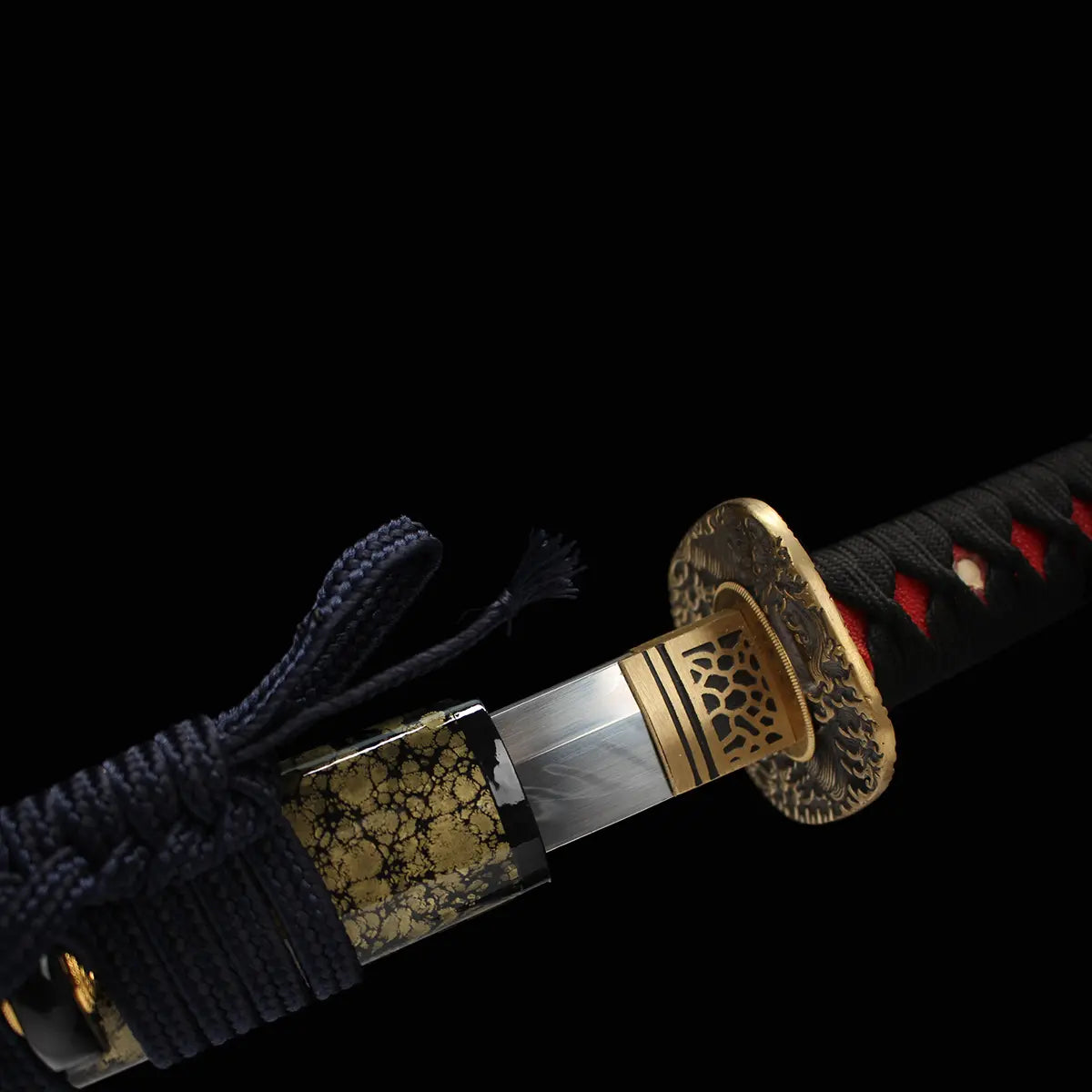 Vue détaillée de l’habaki doré du katana japonais de combat Okinawa, début de la lame polie et sageo noué.
