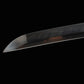 Gros plan sur la pointe (kissaki) tranchante du katana japonais de combat Okinawa, hamon visible sur l’acier T10 poli.