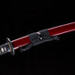 Détail du katana japonais “Kurenai no Tsuki” avec saya rouge laqué brillant, sageo noir soigneusement noué et garde tsuba partiellement visible, photographié sur fond noir studio – katana traditionnel Blade Bushido.