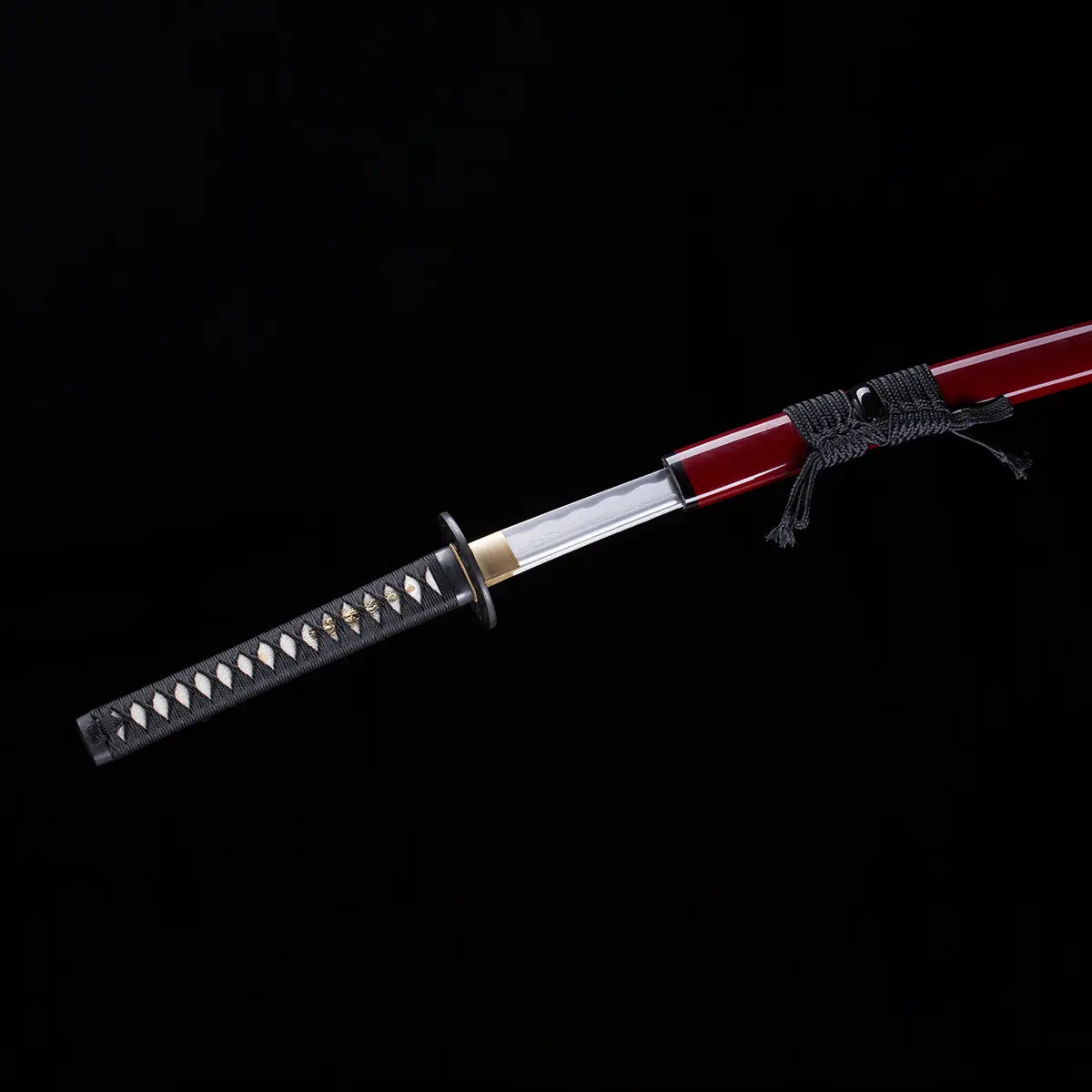 Vue d’ensemble du katana japonais “Kurenai no Tsuki” partiellement dégainé, saya rouge laqué avec sageo noir, poignée tsuka noire tressée avec peau de raie blanche, et garde tsuba noire, photographié sur fond noir studio – katana de collection Blade Bushido.