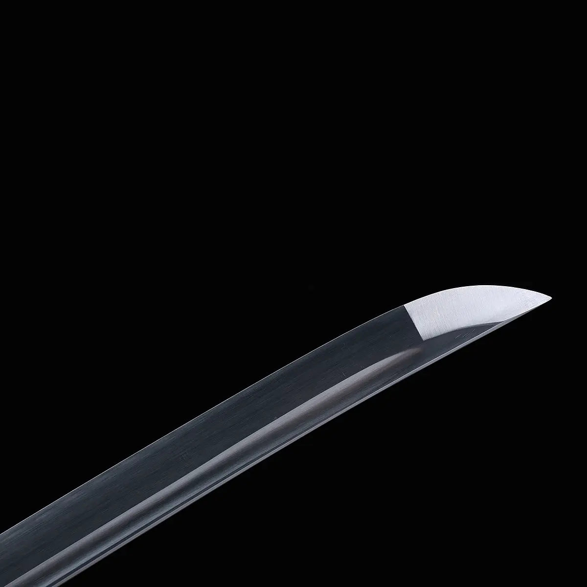 Gros plan de la lame courbe du katana japonais Murasaki no Kage photographiée sur fond noir, acier poli avec ligne de trempe visible et gorge centrale bohi, pointe effilée mettant en valeur la finition de la lame.
