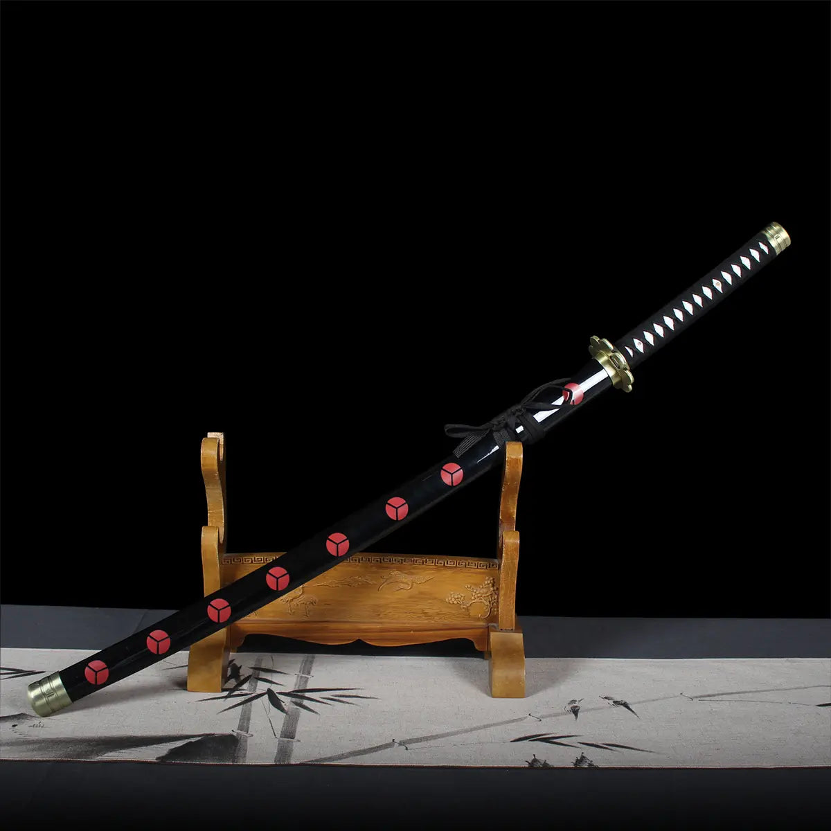 Katana Shusui réplique Roronoa Zoro avec fourreau noir décoré de motifs rouges, manche traditionnel noir et blanc, exposé sur un support en bois japonais