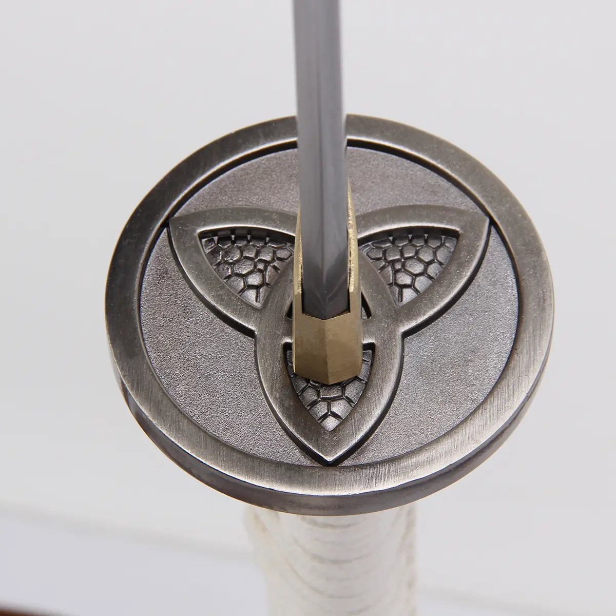 Vue rapprochée de la tsuba (garde) métallique du katana Michonne “Zombie Slayer”, travail artisanal inspiré de The Walking Dead.