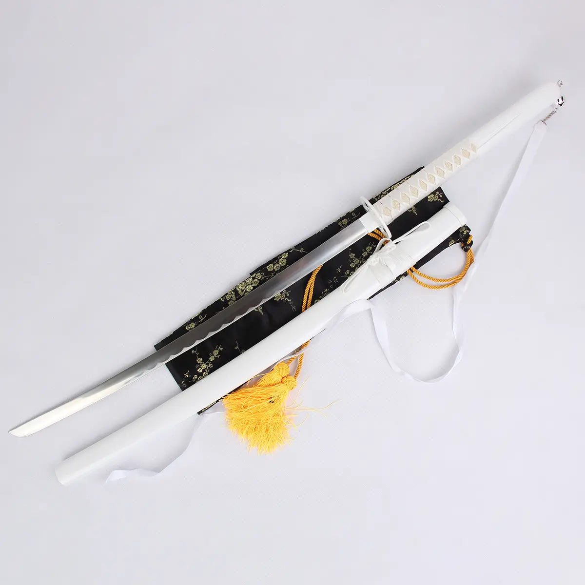 Photo du katana Kuchiki Rukia “Sode no Shirayuki” de Bleach, réplique zanpakutō Bankai en acier carbone avec lame brillante et fourreau blanc, accompagné d’une housse noire brodée et cordons dorés, présenté sur fond clair.