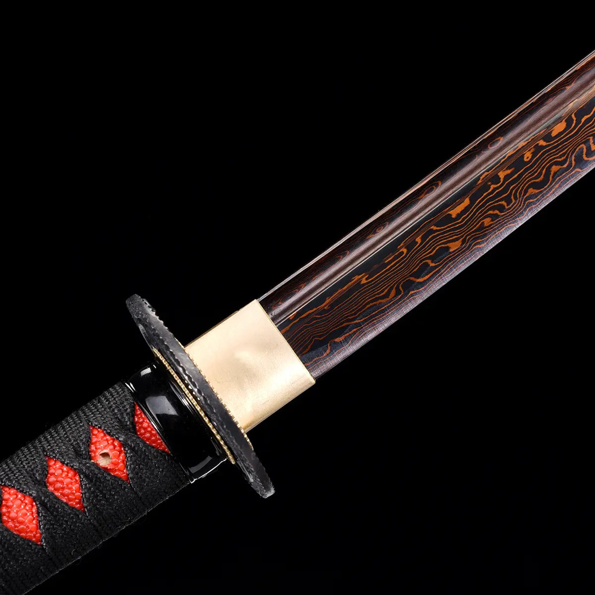 Détail rapproché du katana japonais Ryū Honō montrant la lame damas rouge et noire, le habaki doré et la poignée tsuka noire tressée de rouge. Photo sur fond noir mettant en avant la finesse des veinures du damas et la qualité artisanale Blade Bushido.